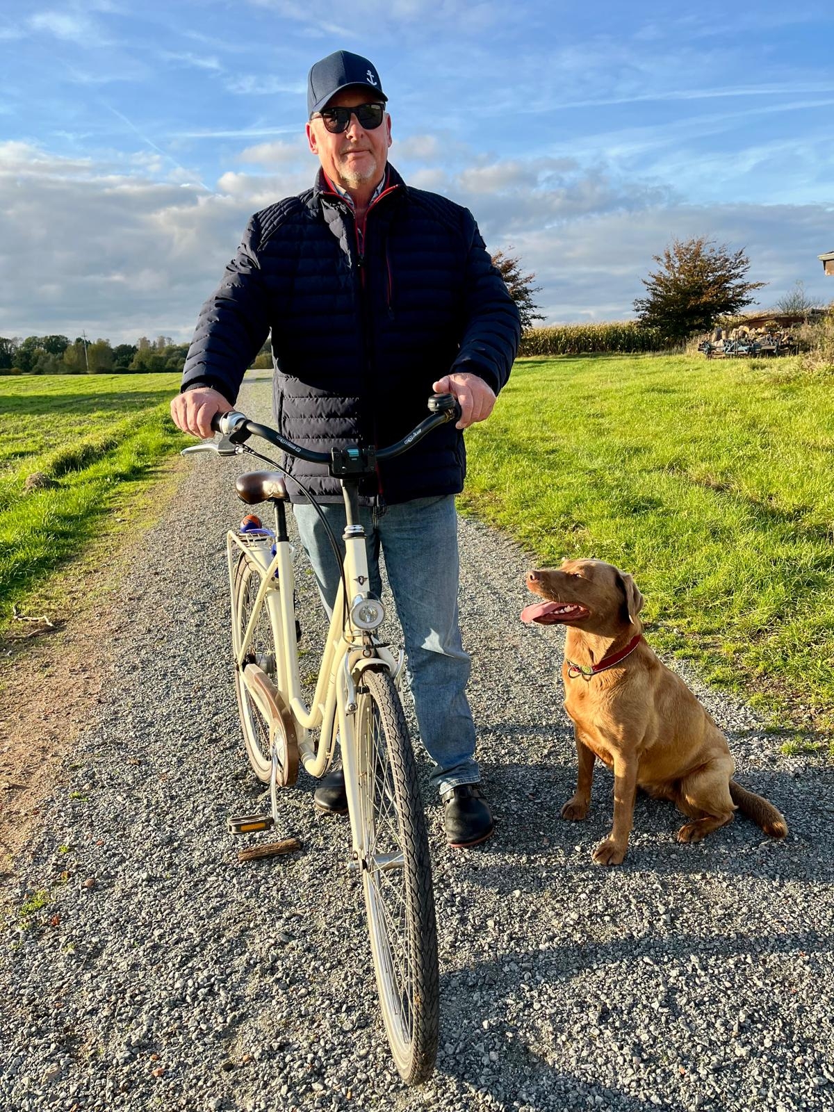 Feldweg mit Radfahrer und Hund
