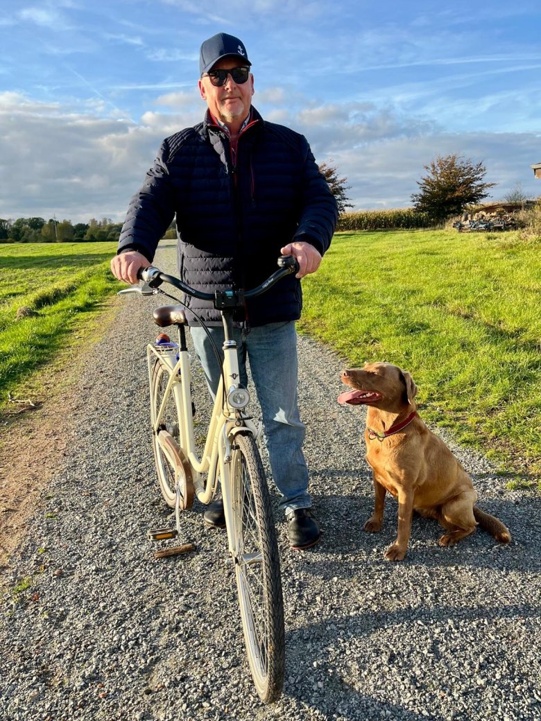 Feldweg mit Radfahrer und Hund